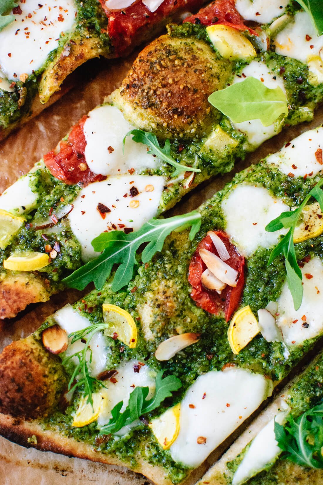 Summertime arugula-almond pesto pizza with a simple whole wheat crust