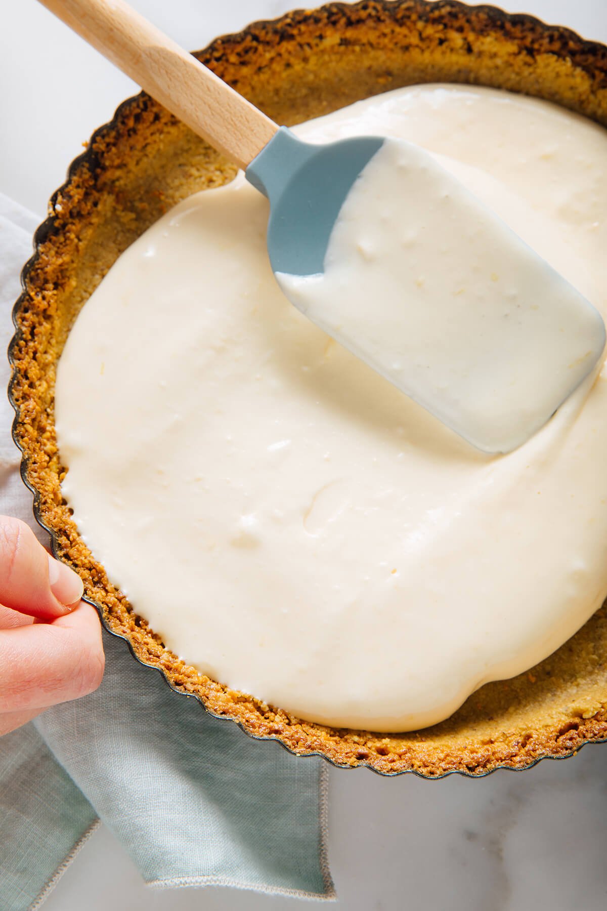 spreading cheesecake filling into baked crust
