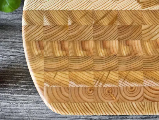 Larch Wood Cutting Board on display with tomatoes and lettuce on a counter.