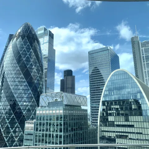 London, England: Shiny glass buildings on blue cloud day in London