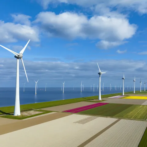 Wind turbines on a levee and offshore in Flevoland, The Netherlands, during springtime seen from above. Flevoland is a modern polder in the former Zuiderzee designed initially to create more land for farming.