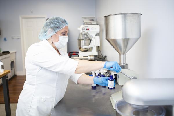 Eliza Desmarais fills a bottle of Sohma Naturals product