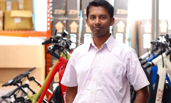 Man in front of several ebikes