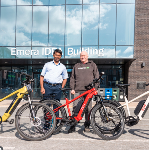 Two men standing with several ebikes