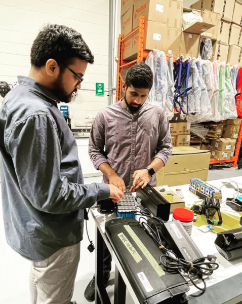 Two men working on ebike components