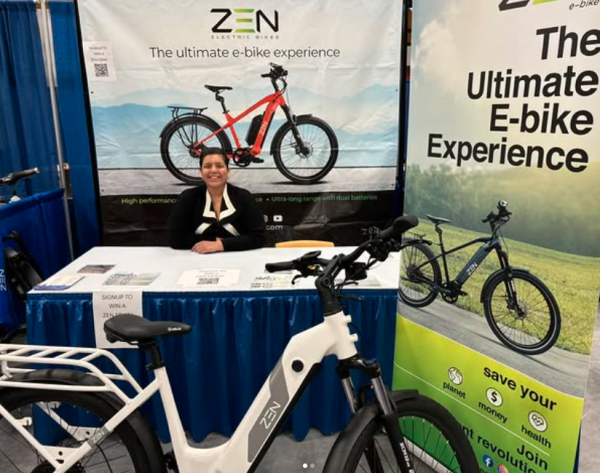 Woman at table with ebikes on display at an event