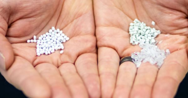 Hands holding tiny white pieces of plastic