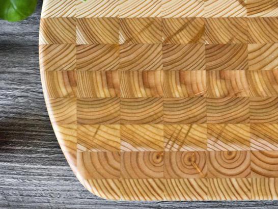 Larch Wood Cutting Board on display with tomatoes and lettuce on a counter.