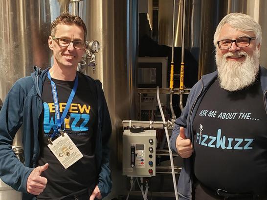 Guy Tipton and Cyril Meagher, founders of BrewWizz, standing with their creation, the FIZZWIZZ