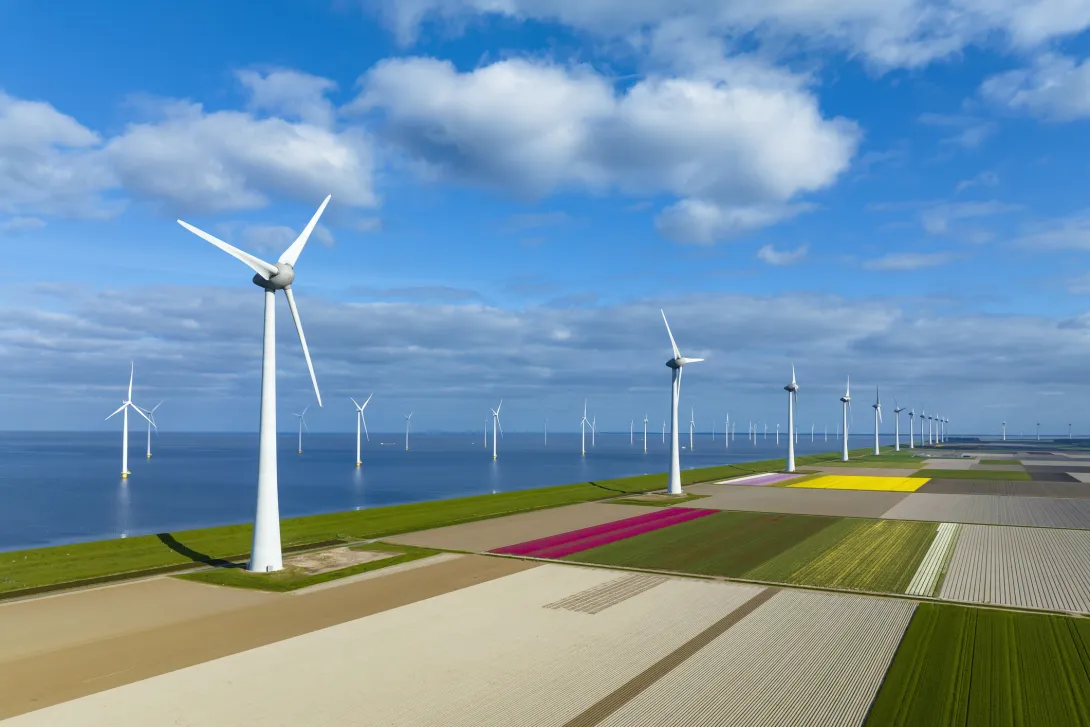 Wind turbines on a levee and offshore in Flevoland, The Netherlands, during springtime seen from above. Flevoland is a modern polder in the former Zuiderzee designed initially to create more land for farming.